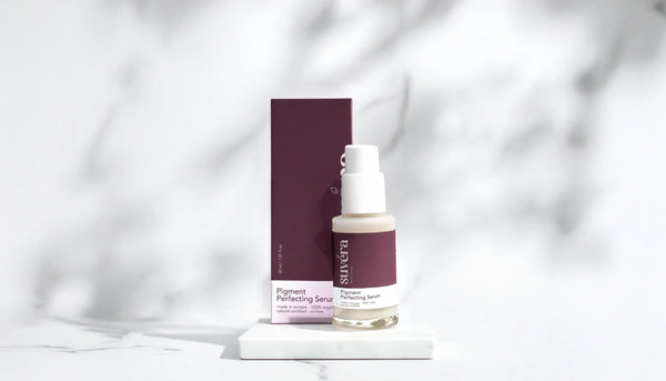Suvéra skincare serum bottle upright on mirrored floor and mirrored walls, front-facing shot with elegant, minimalistic reflections.
