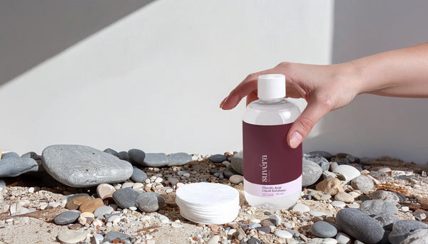 Luxurious Suvéra vegan and organic skincare products arranged on a warm stone vanity with sunlight, fresh botanicals, and linen textures, symbolizing clean beauty and mindful self-care.