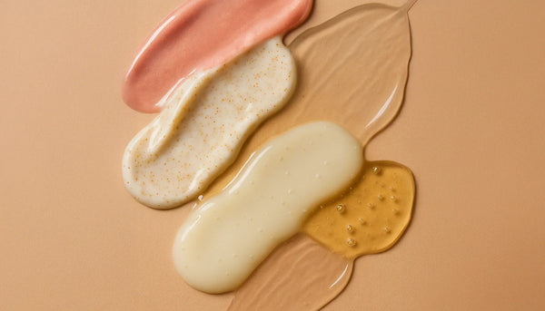 Suvera Beauty Blog — macro close-up of overlapping skincare textures (gel, cream, serum, oil) on a warm beige background