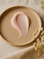 Pink cream on a beige plate with dried flowers on a beige fabric background Hydrating Serum
