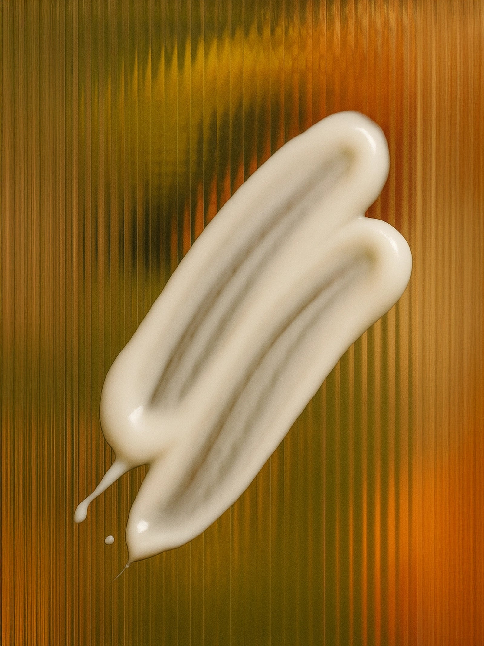 White cream smear on a textured brown background Suvéra moisturizing conditioner dollop on rippled glass, finger-smoothed texture with soft sheen, natural self-care hair treatment close-up.
