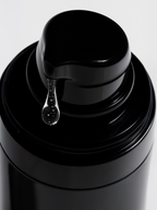 Close-up of a black bottle cap with a droplet of liquid on a white background Oil-Free Hydrating Gel