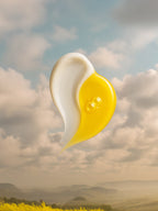 Half-white, half-yellow object against a cloudy sky with a landscape in the background Weightless Duo Collagen Boost Serum  Natural Retinol Alternative Oil Serum