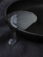 Black and gray guitar pick on a textured black surface