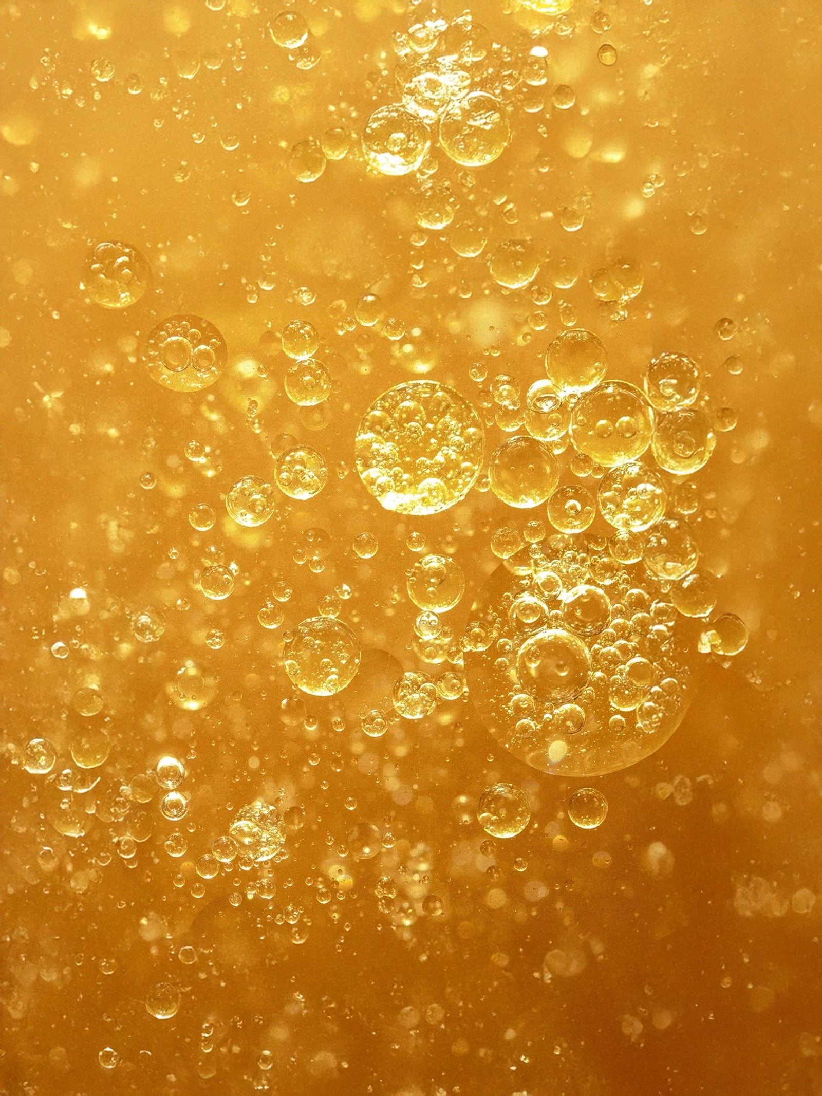 Close-up of beer with bubbles on a golden background