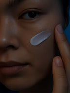 Person applying a skincare product to their face with a finger