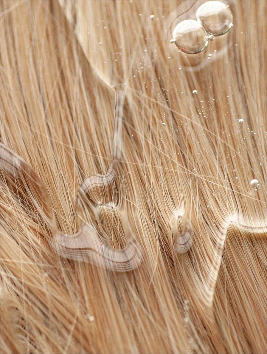 Close-up texture shot of Suvéra keratin product showing a natural wood or fiber pattern