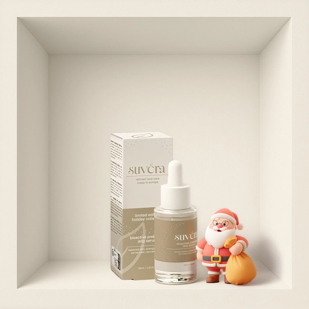 Skincare serum bottle with packaging and a Santa Claus figurine on a neutral background