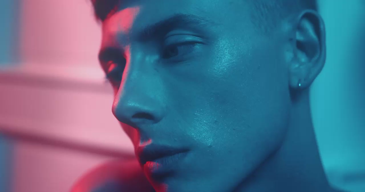 Male skincare model with face care product, natural and certified cream in colorful room