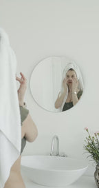 Female skincare model for Suvera applying cream Collagen natural serum to face in bathroom