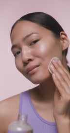 Woman applying face care toner to smooth face